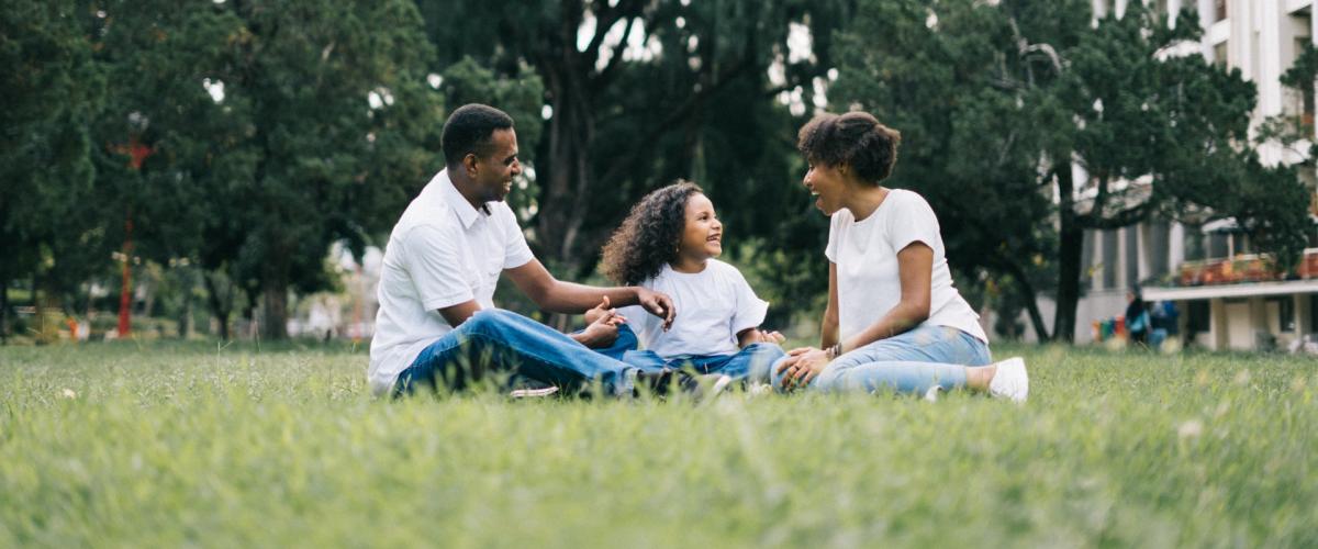 family sitting on grass